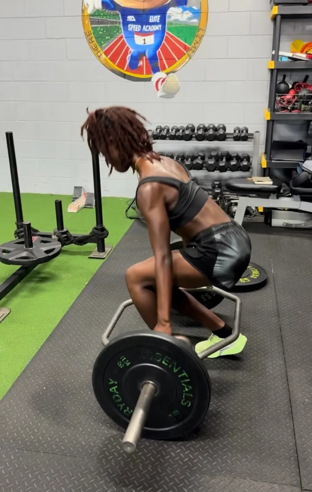 Athlete gripping a loaded trap bar on the gym floor, ready to lift
